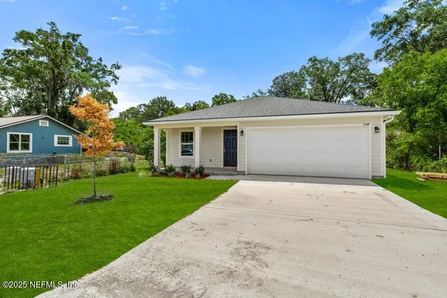 a view of backyard of house with green space