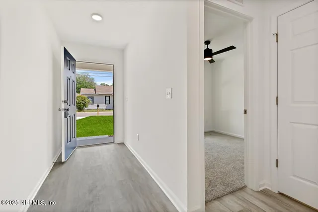 a view of a hallway with wooden floor