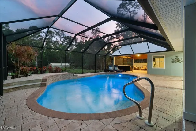 a view of a swimming pool with a table and chairs under an umbrella