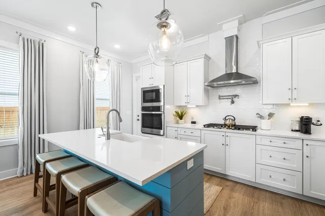 a kitchen with stainless steel appliances kitchen island granite countertop a sink a stove a dining table and chairs