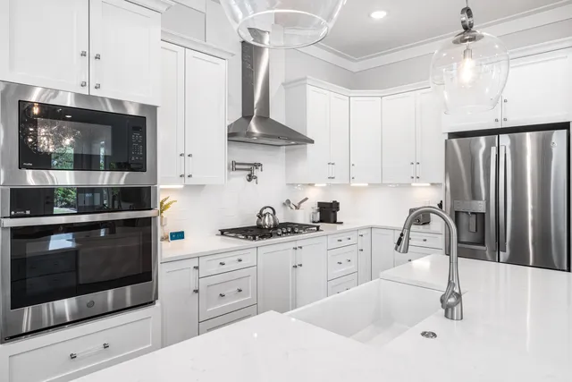 a kitchen with stainless steel appliances granite countertop a sink a stove and cabinets