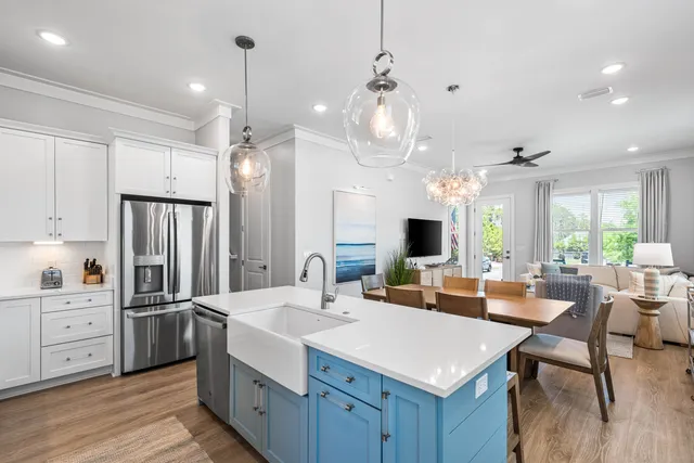 a kitchen with stainless steel appliances a sink a stove and white cabinets