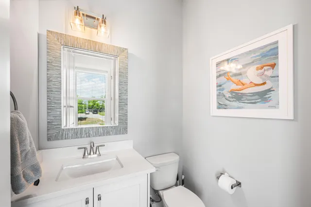 a bathroom with a toilet a sink and a mirror