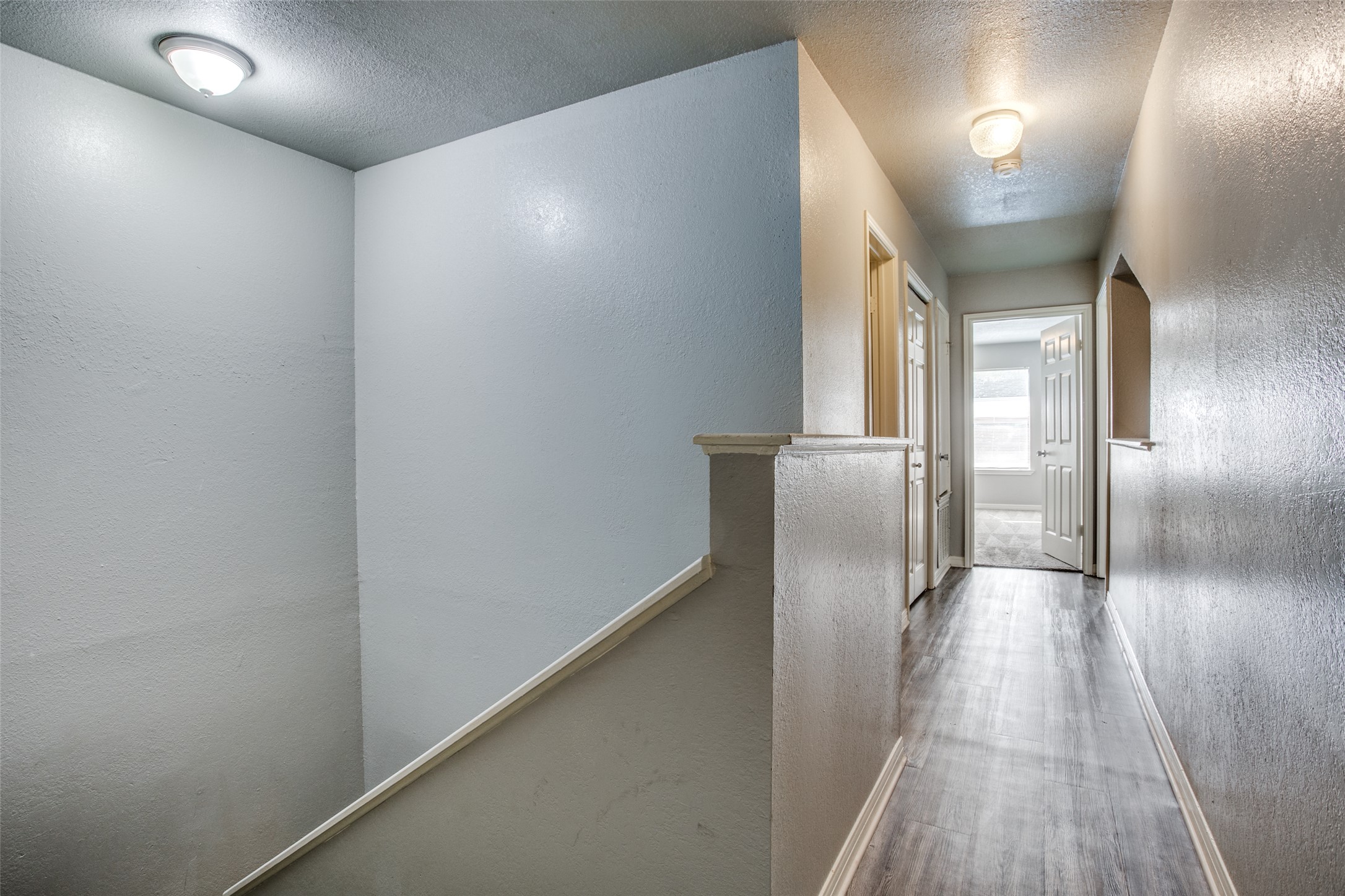 106 Verna Spur, Unit B Georgetown, TX 78628 - Photo 17 of 25 A well-lit landing provides access to various rooms, featuring durable wood flooring and streamlined design.