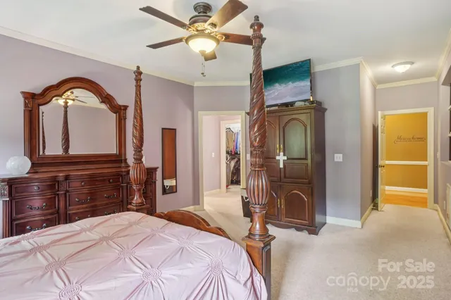 a bedroom with a bed a flat tv screen and dresser