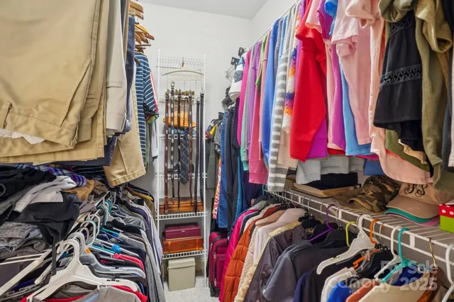 a view of walk in closet with clothes
