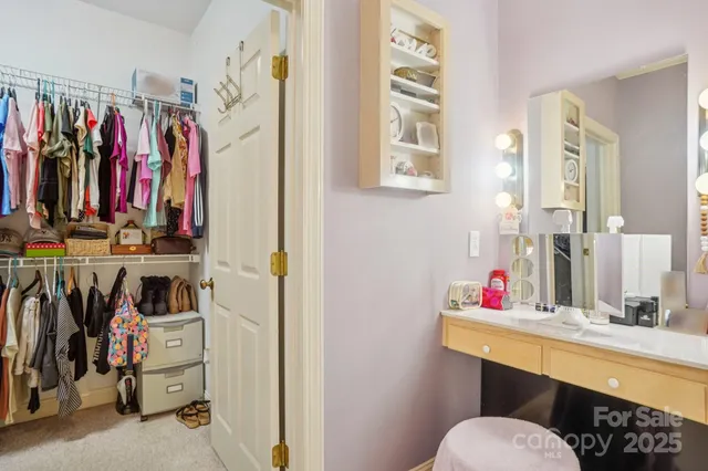 a view of walk in closet with clothes and shoes