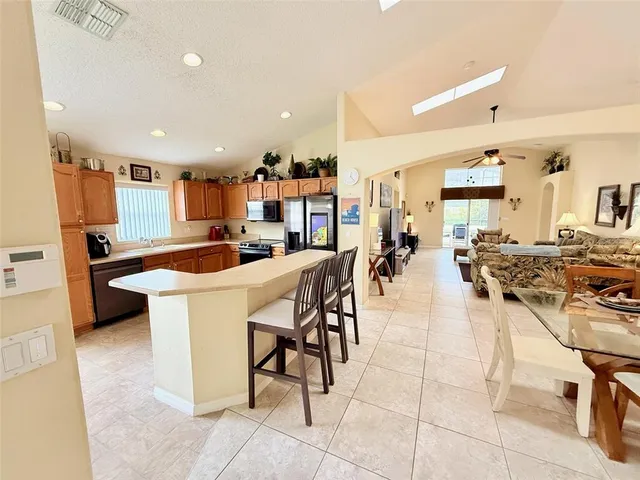 a kitchen with stainless steel appliances a stove a sink a microwave a refrigerator and cabinets