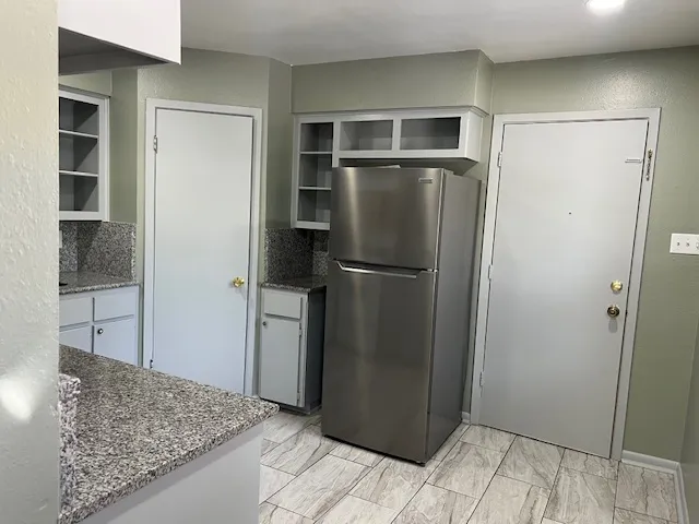 a kitchen with a refrigerator and microwave