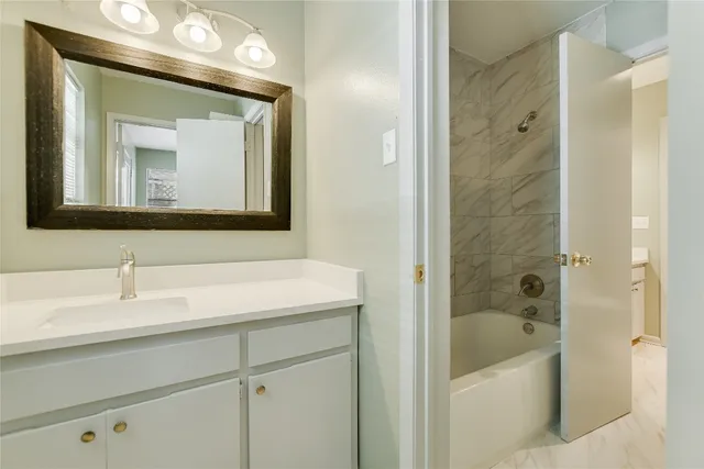 a bathroom with a tub a sink and mirror