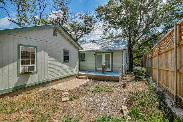 a view of a house with a yard and wooden fence