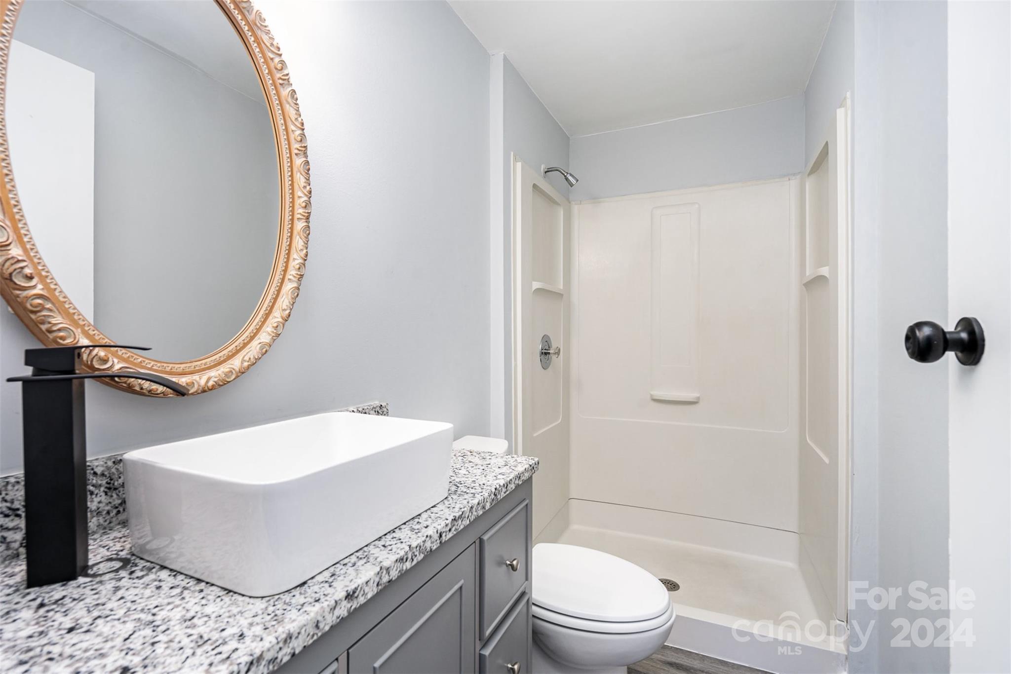 1101 Scaleybark Road, Unit B Charlotte, NC 28209 - Photo 13 of 18 a bathroom with a granite countertop sink a toilet and shower