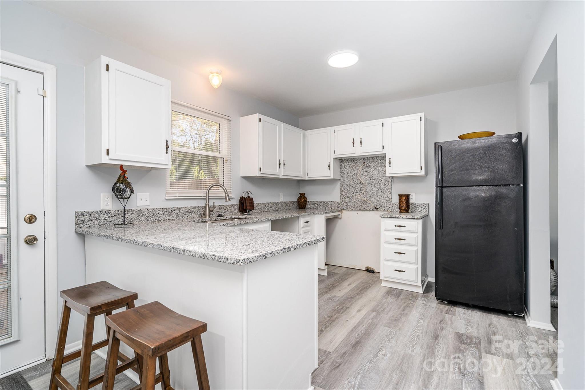 1101 Scaleybark Road, Unit B Charlotte, NC 28209 - Photo 5 of 18 a kitchen with stainless steel appliances granite countertop a refrigerator sink and cabinets