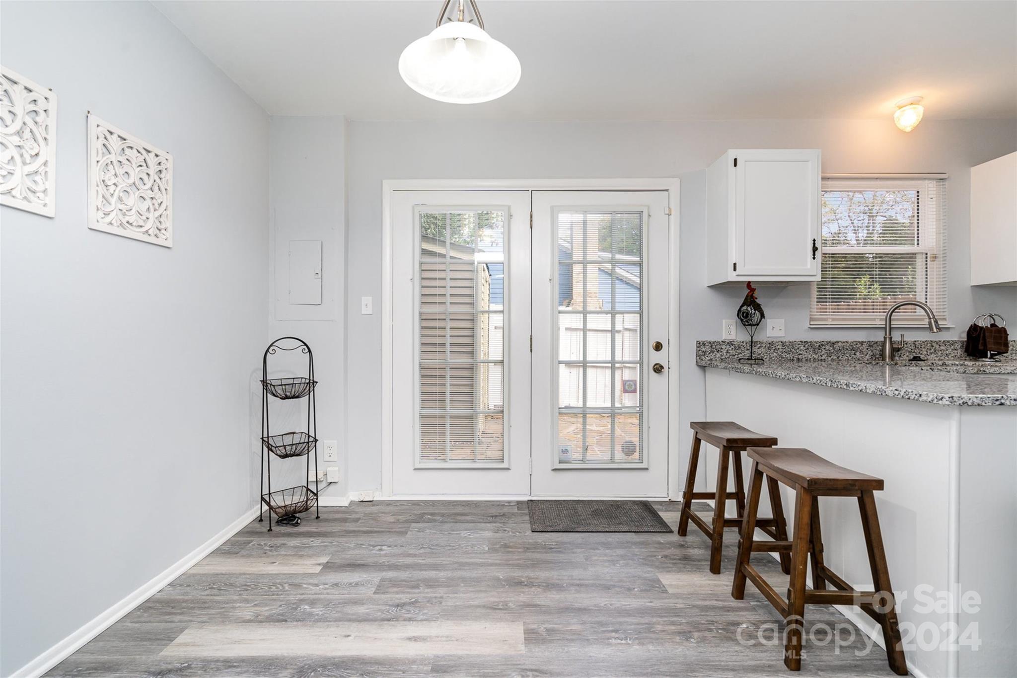 1101 Scaleybark Road, Unit B Charlotte, NC 28209 - Photo 9 of 18 a kitchen with granite countertop wooden floors and white cabinets