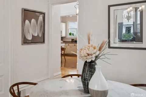 a open dining room with stainless steel appliances kitchen island granite countertop a table chairs refrigerator and microwave