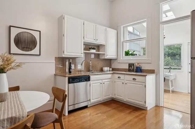 a kitchen with stainless steel appliances granite countertop a table and chairs in it