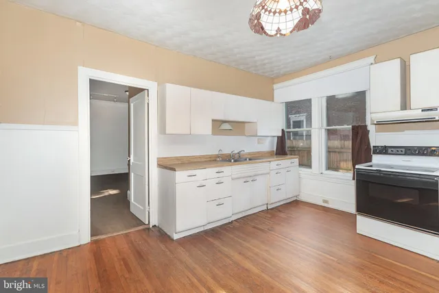 a kitchen with cabinets wooden floor and a fireplace