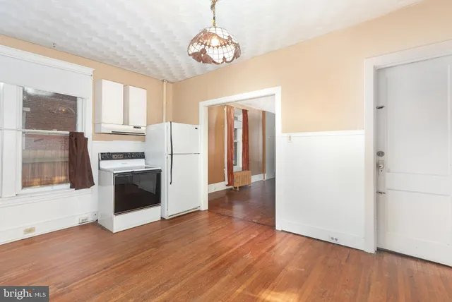 a view of kitchen with granite countertop stainless steel appliances and wooden floor