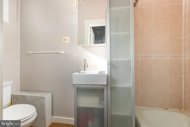 a bathroom with a sink a toilet and shower