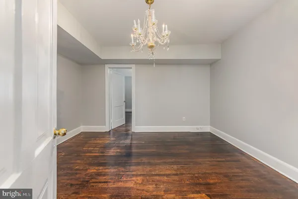 a view of wooden floor and chandelier in closet