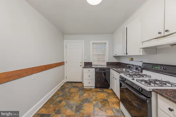 a kitchen with a stove a sink and cabinets