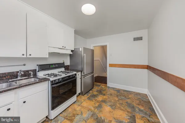 a kitchen with granite countertop a stove and a refrigerator