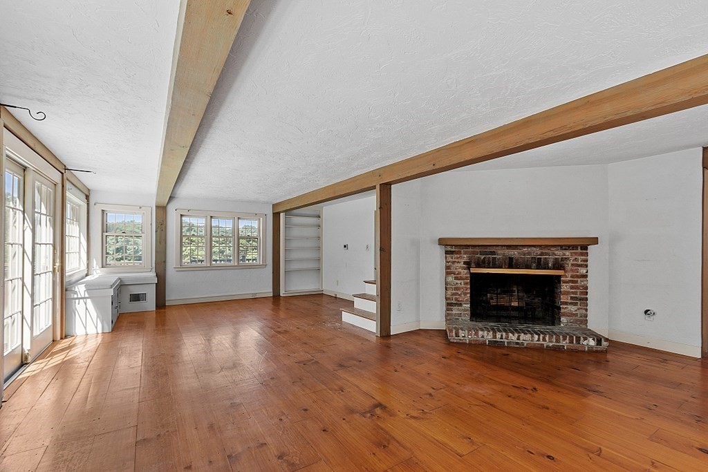 19 Conant Road Lincoln, MA 01773 - Photo 12 of 42 an empty room with wooden floor fireplace and windows