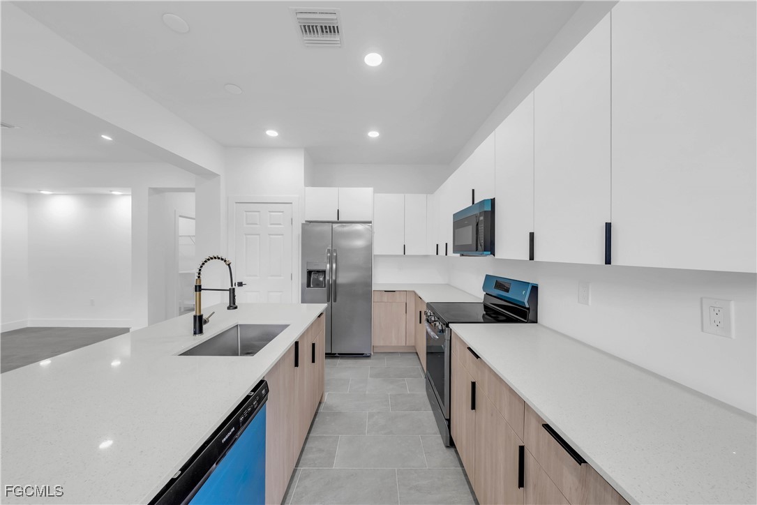 3224 53rd Street West Lehigh Acres, FL 33971 - Photo 7 of 22 a kitchen with counter top space stainless steel appliances and cabinets