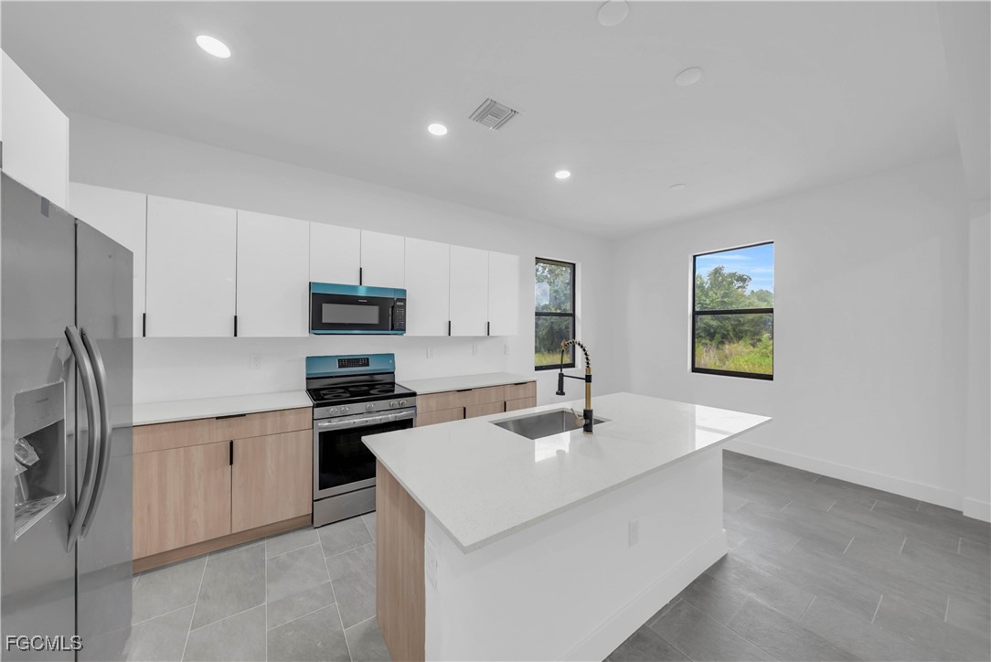 3224 53rd Street West Lehigh Acres, FL 33971 - Photo 8 of 22 a kitchen with stainless steel appliances a sink a stove and a refrigerator