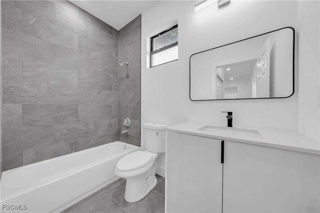 3224 53rd Street West Lehigh Acres, FL 33971 - Photo 9 of 14 a bathroom with a toilet sink and bathtub