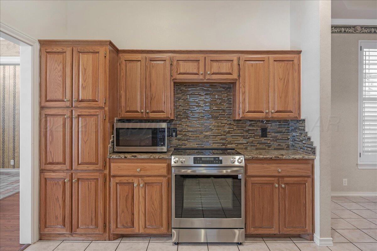 5823 Nicholas Circle Amarillo, TX 79109 - Photo 12 of 31 a kitchen with stainless steel appliances wooden cabinets and a stove top oven