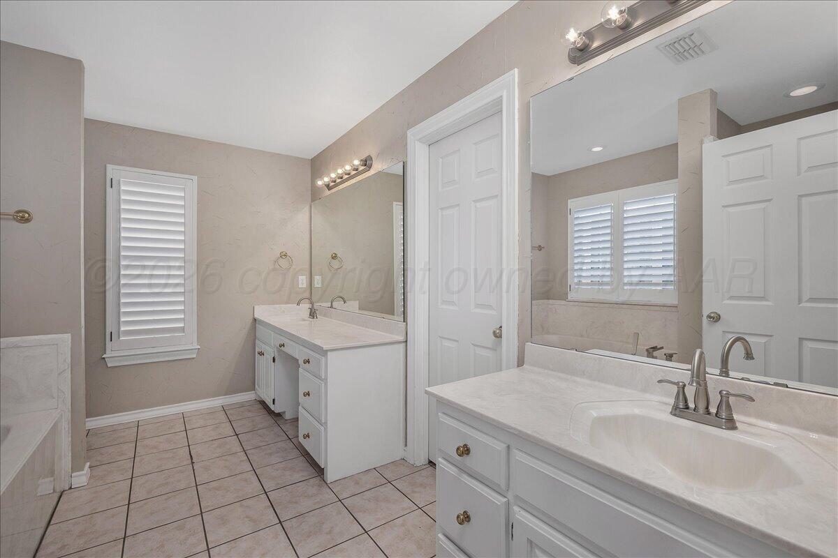 5823 Nicholas Circle Amarillo, TX 79109 - Photo 17 of 31 a bathroom with a sink a vanity a mirror and a bathtub