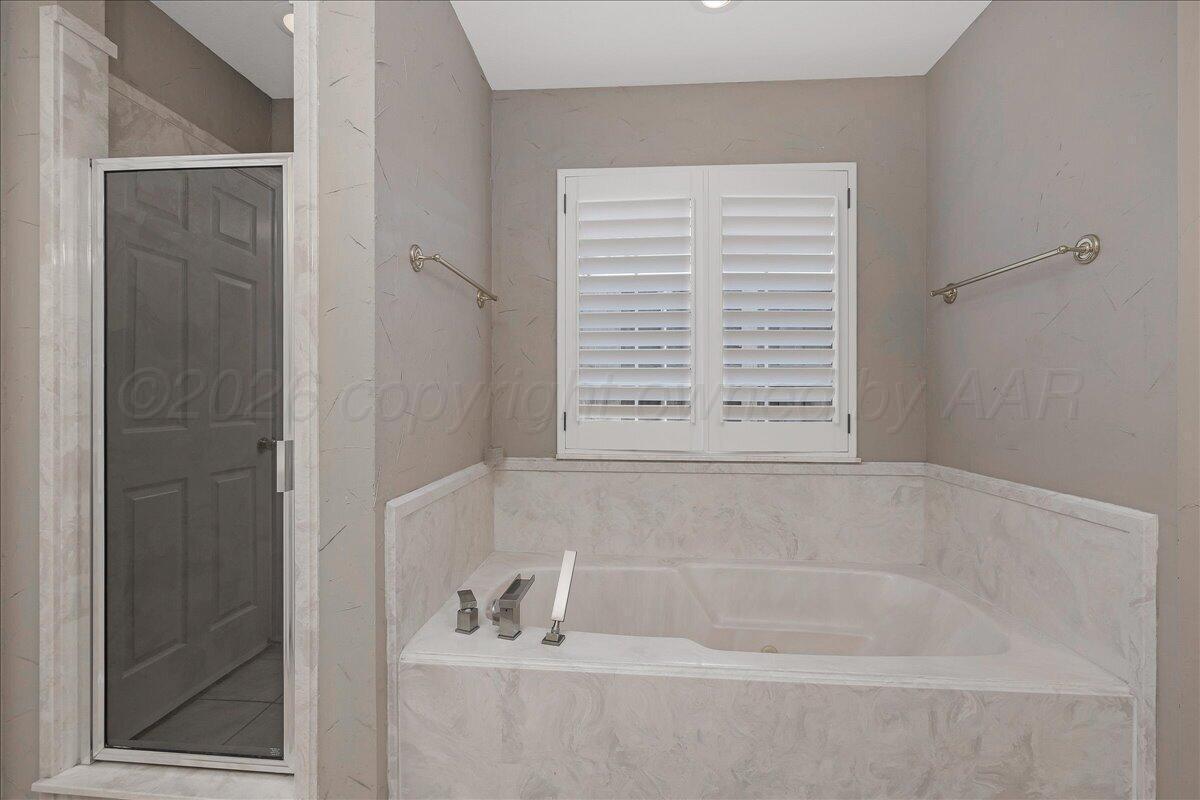 5823 Nicholas Circle Amarillo, TX 79109 - Photo 18 of 31 a bathroom with bathtub next to a window