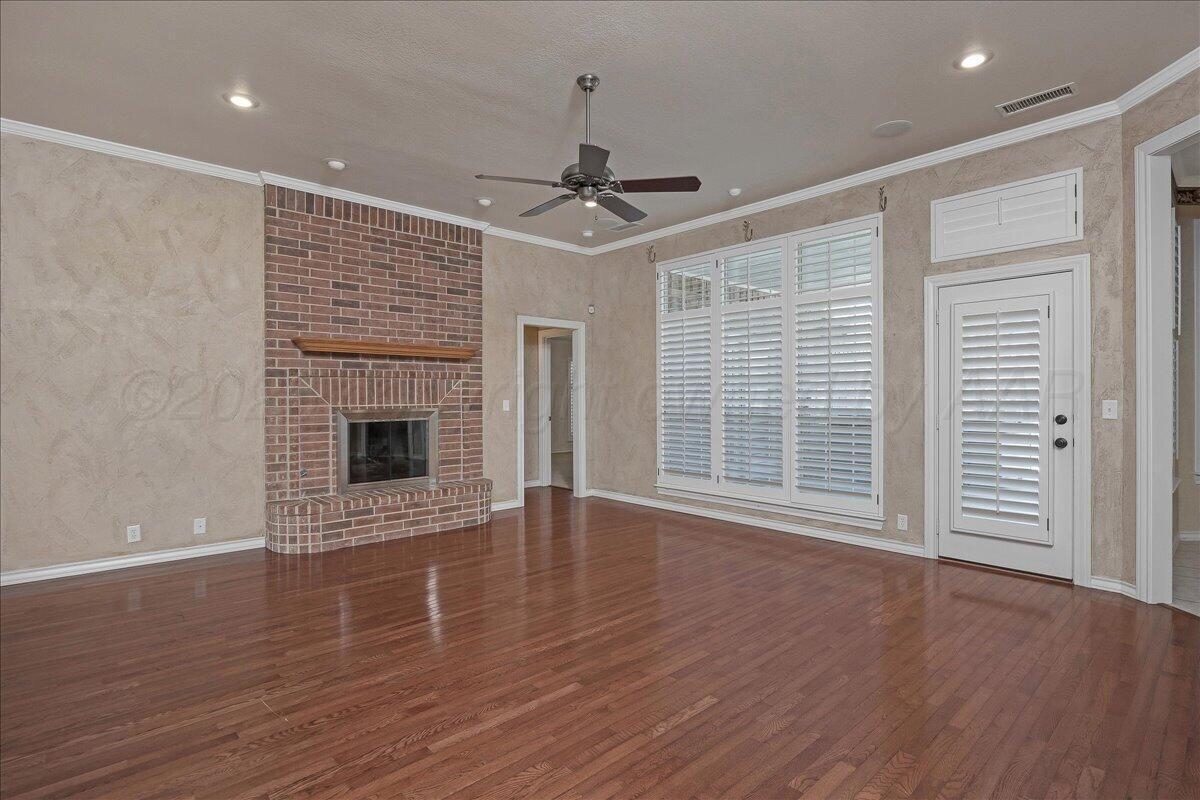 5823 Nicholas Circle Amarillo, TX 79109 - Photo 5 of 31 a view of an empty room with wooden floor fireplace and a window