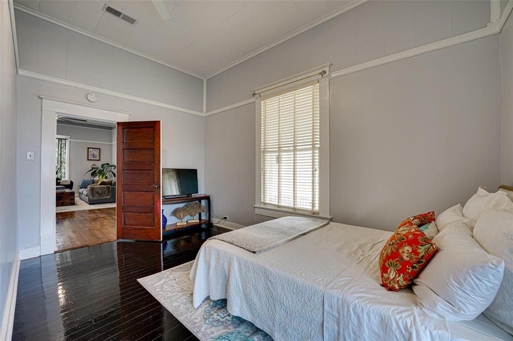 1515 Caddo Street Commerce, TX 75428 - Photo 16 of 23 a bedroom with a bed and wooden floor