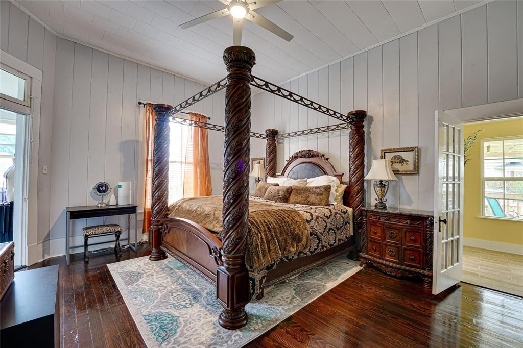 1515 Caddo Street Commerce, TX 75428 - Photo 20 of 23 a bedroom with a bed next to a window with a chandelier