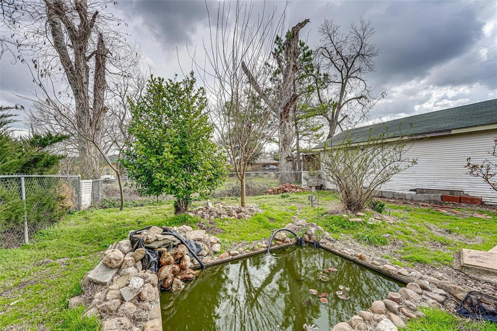 1515 Caddo Street Commerce, TX 75428 - Photo 23 of 23 a view of a backyard with plants and a patio