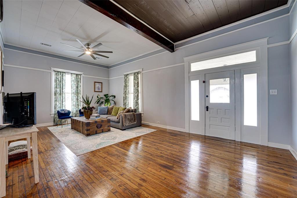 1515 Caddo Street Commerce, TX 75428 - Photo 9 of 23 a living room with furniture wooden floor and a fireplace