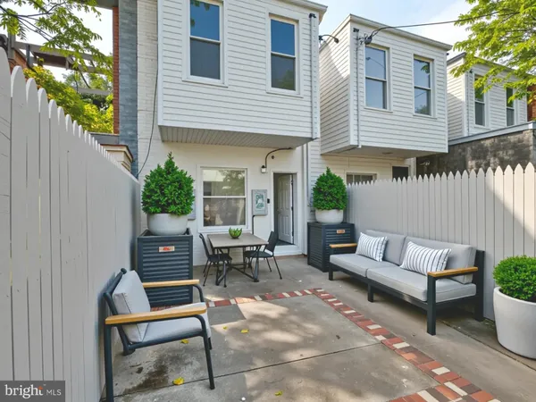a backyard of a house with barbeque oven and outdoor seating