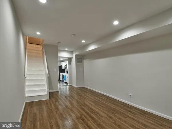a view of a hallway with wooden floor and staircase