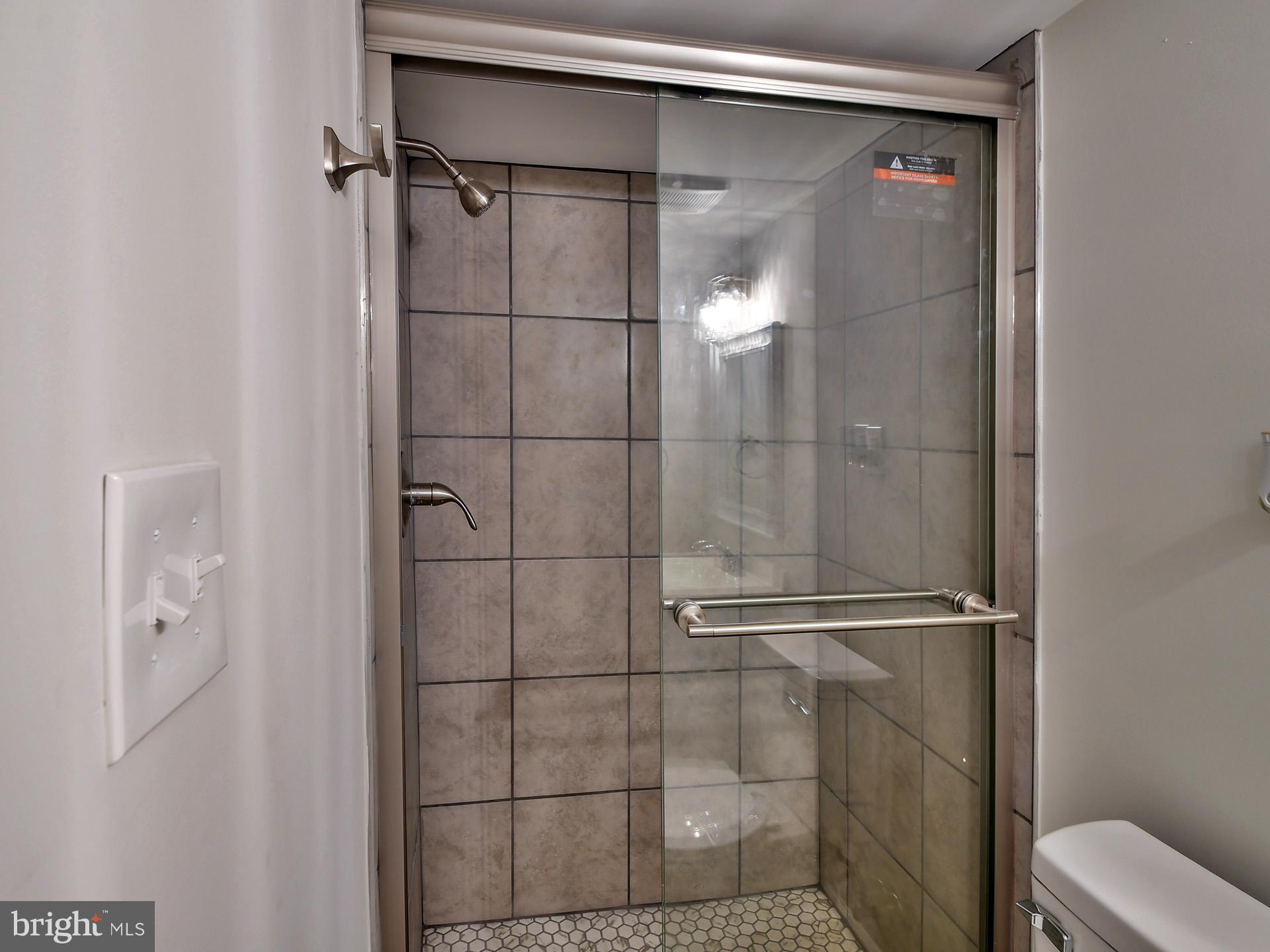 2114 Cliftwood Avenue Baltimore, MD 21213 - Photo 23 of 58 a bathroom with a glass shower door