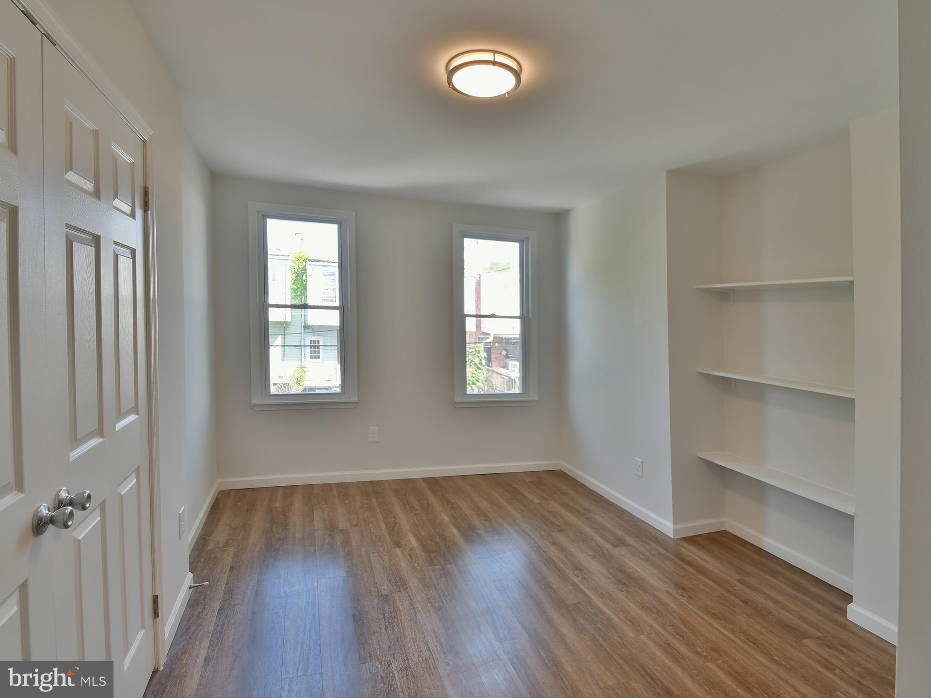 2114 Cliftwood Avenue Baltimore, MD 21213 - Photo 32 of 58 a view of an empty room with a window and wooden floor