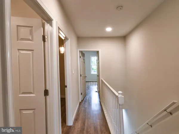 a view of a hallway with wooden floor and closet area