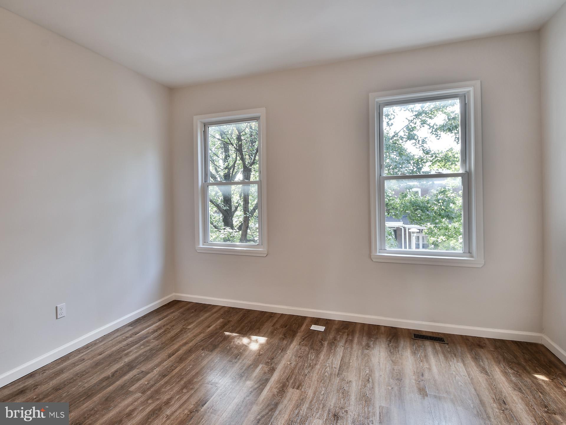 2114 Cliftwood Avenue Baltimore, MD 21213 - Photo 42 of 58 a view of an empty room with wooden floor and a window