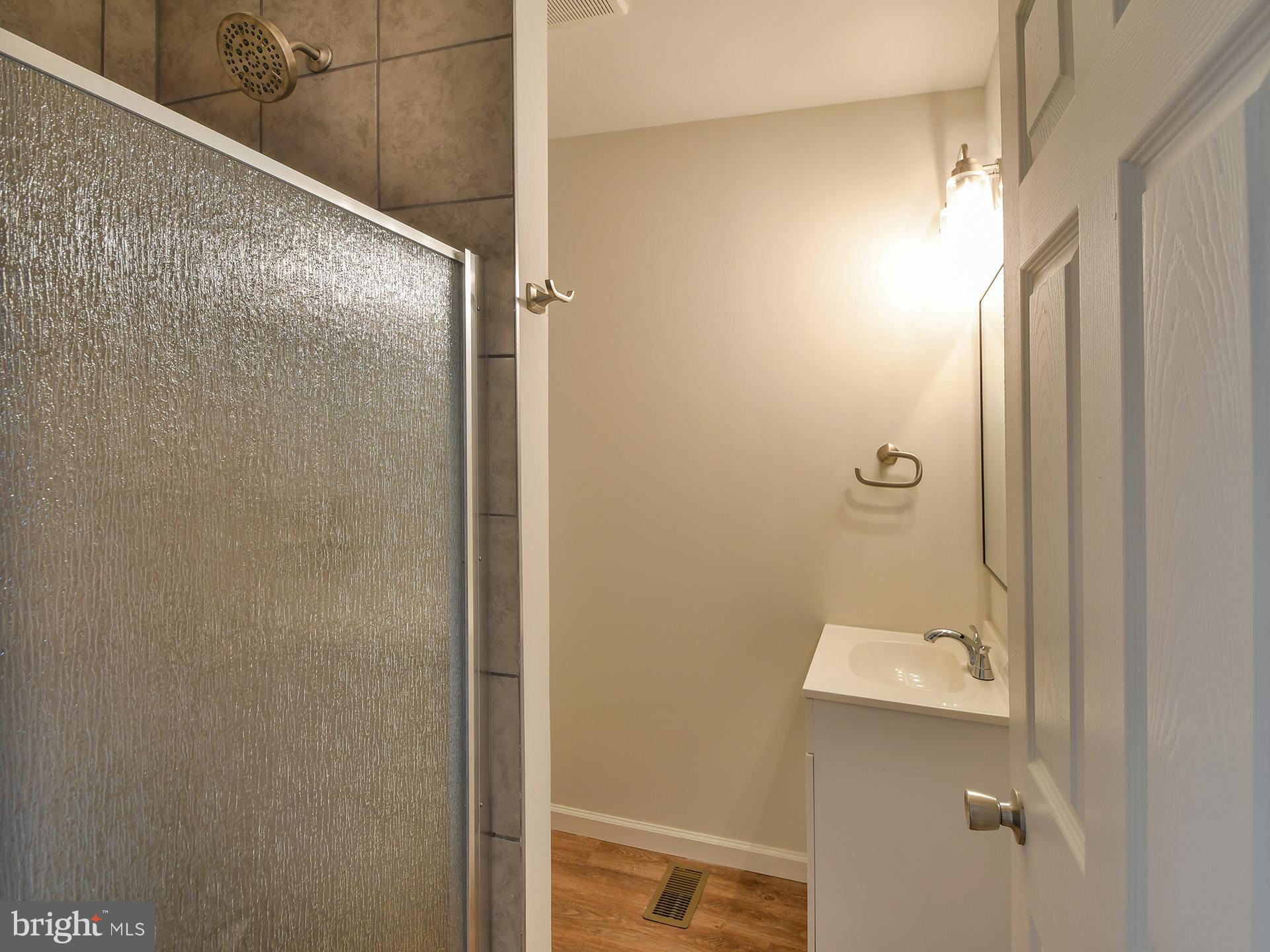 2114 Cliftwood Avenue Baltimore, MD 21213 - Photo 46 of 58 a bathroom with a granite countertop shower and a toilet