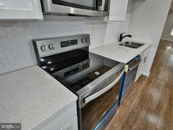 a stove top oven sitting inside of a kitchen