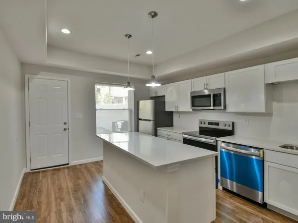 a kitchen with a sink a microwave a refrigerator and cabinets