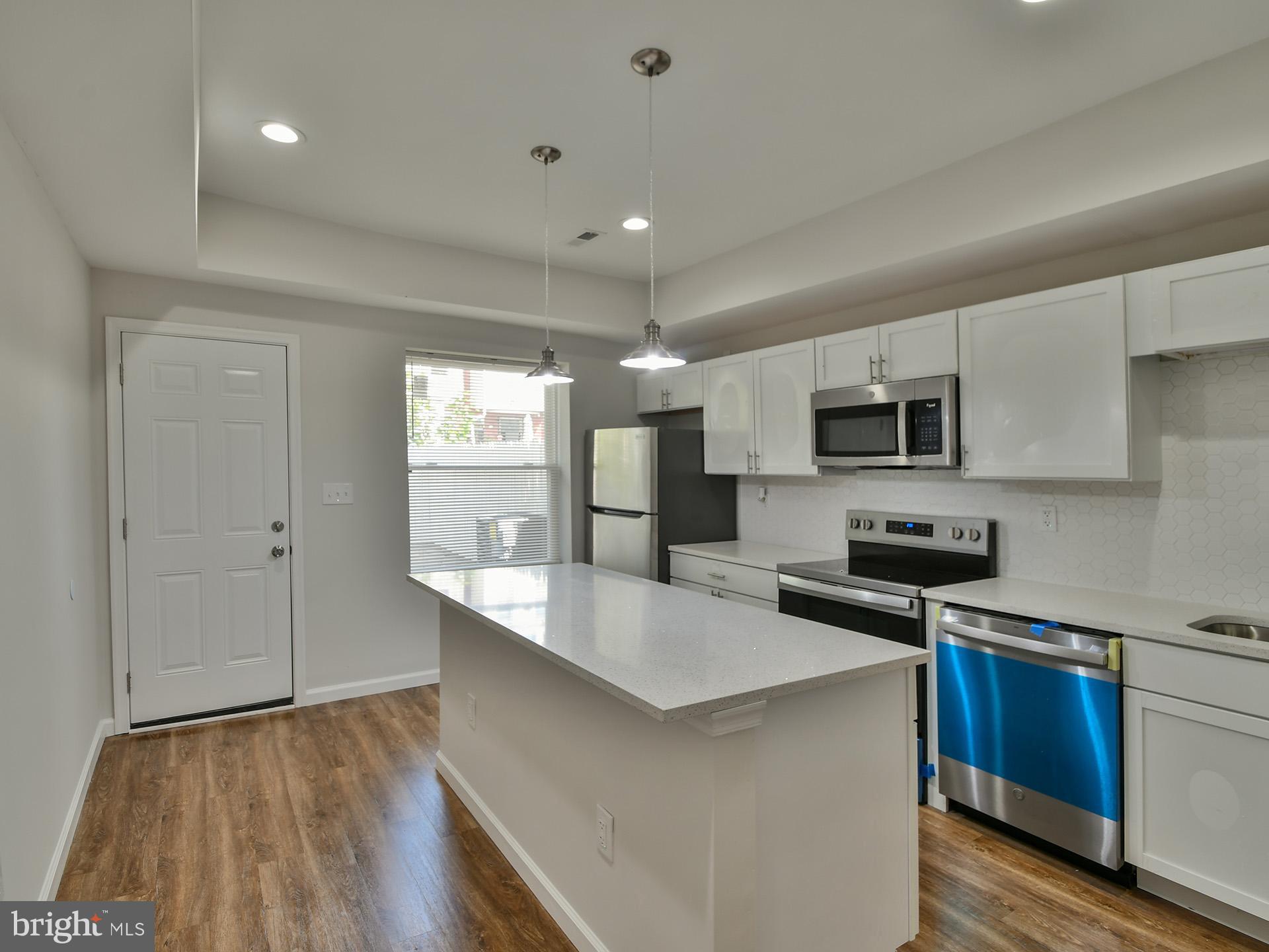 2114 Cliftwood Avenue Baltimore, MD 21213 - Photo 9 of 58 a large kitchen with stainless steel appliances lots of counter space and wooden floor