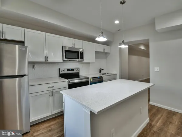 a kitchen with a refrigerator and a stove top oven