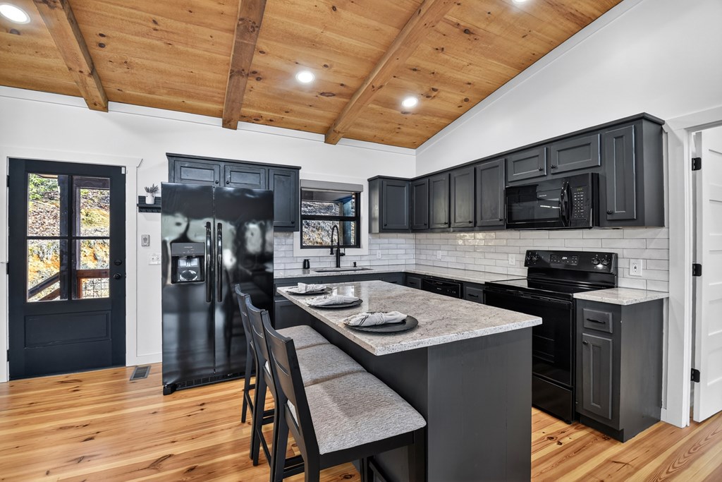 238 Hooch Holler Lane Morganton, GA 30560 - Photo 23 of 49 a kitchen with stainless steel appliances granite countertop a refrigerator a stove top oven a sink dishwasher and wooden cabinets